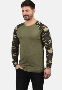 Olijfgroene long-sleeve top met camouflageprint mouwen; geribbelde kraag; zachte katoenmix; losse pasvorm; inclusief een klein logo-label aan de zoom.