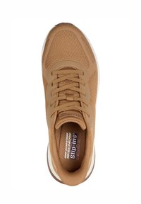 Zapatilla en tonos marrones con un upper de malla texturizada, cordones y una media suela blanca. La plantilla cuenta con las marcas "Slip-Ins" y "Memory Foam".