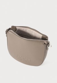 Šedá kožená křížová taška s hladkým povrchem, zipovým uzavřením a vyraženým logem na přední straně, s zakřiveným tvarem.