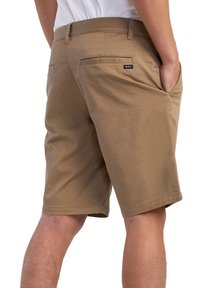 Tan shorts lavet af et glat, letvægtsstof. Har to baglommer med et lille sort logo-tag, ren kant og afslappet pasform.