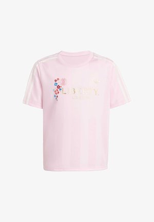 T-shirt rosa chiaro a maniche corte con strisce bianche sulle maniche, scritta dorata "LIBERTY LONDON", piccolo ricamo floreale e logo Adidas sul petto.
