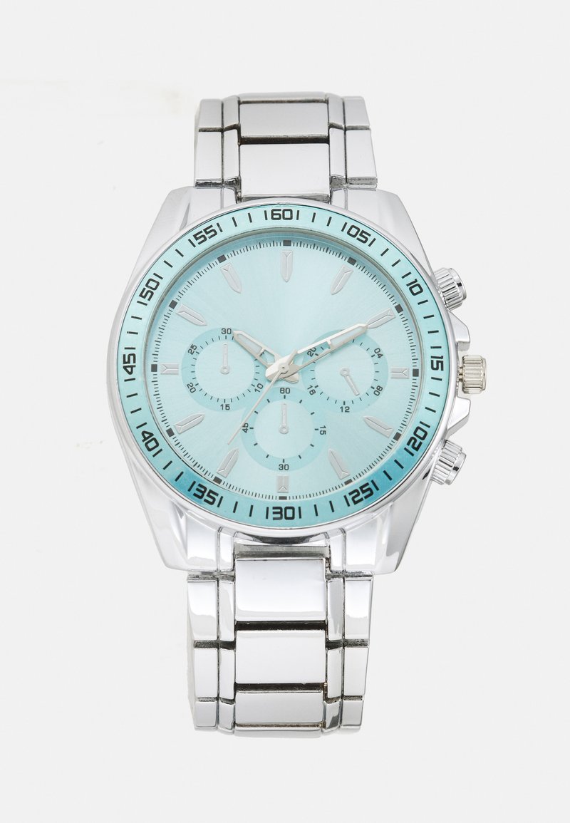 Montre en acier inoxydable argenté avec un cadran bleu clair, trois sous-cadrans, des marquages noirs et un bracelet à maillons métalliques.