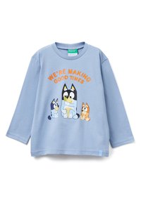 Jasnoniebieska koszula z długim rękawem z kreskówkowym motywem trzech psów oraz pomarańczowym napisem "WE'RE MAKING GOOD TIMES" nad wzorem.