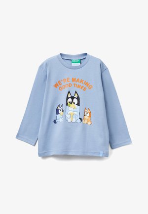 Jasnoniebieska koszula z długim rękawem z kreskówkowym motywem trzech psów oraz pomarańczowym napisem "WE'RE MAKING GOOD TIMES" nad wzorem.