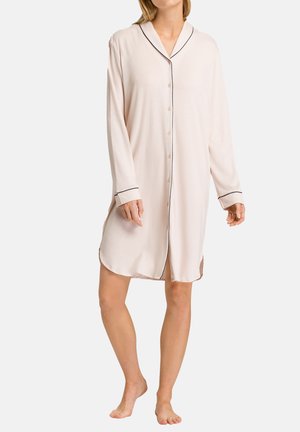 Una lunga camicia da notte rosa chiaro con piping nero lungo il colletto e i polsini. Realizzata in un tessuto morbido, presenta bottoni lungo il davanti e spacchi sui fianchi.