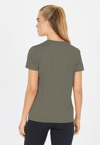 Kortärmad, olivgrön träningströja med en slät och lätt textur. Enkel design med rund halsringning och rak nederkant.