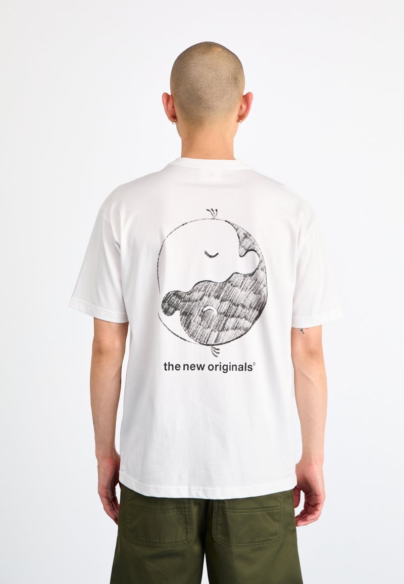 Hvid kortærmet t-shirt med et sort grafisk design på ryggen, der viser et cirkulært mønster og teksten "the new originals."