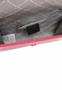 Pink synthetic handbag interior features grey fabric lining with a diamond pattern, side pocket, and brand label. Includes a magnetic snap closure.