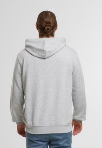 Grauer Kapuzenpullover mit lockerer Passform, strukturiertem Stoff und gerippten Bündchen und Saum. Verfügt über eine große Kapuze und überschnittene Schulternaht.