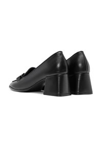 Chaussures à talons carrés en cuir noir avec une finition lisse, un embout pointu et un détail de nœud décoratif à l'avant.