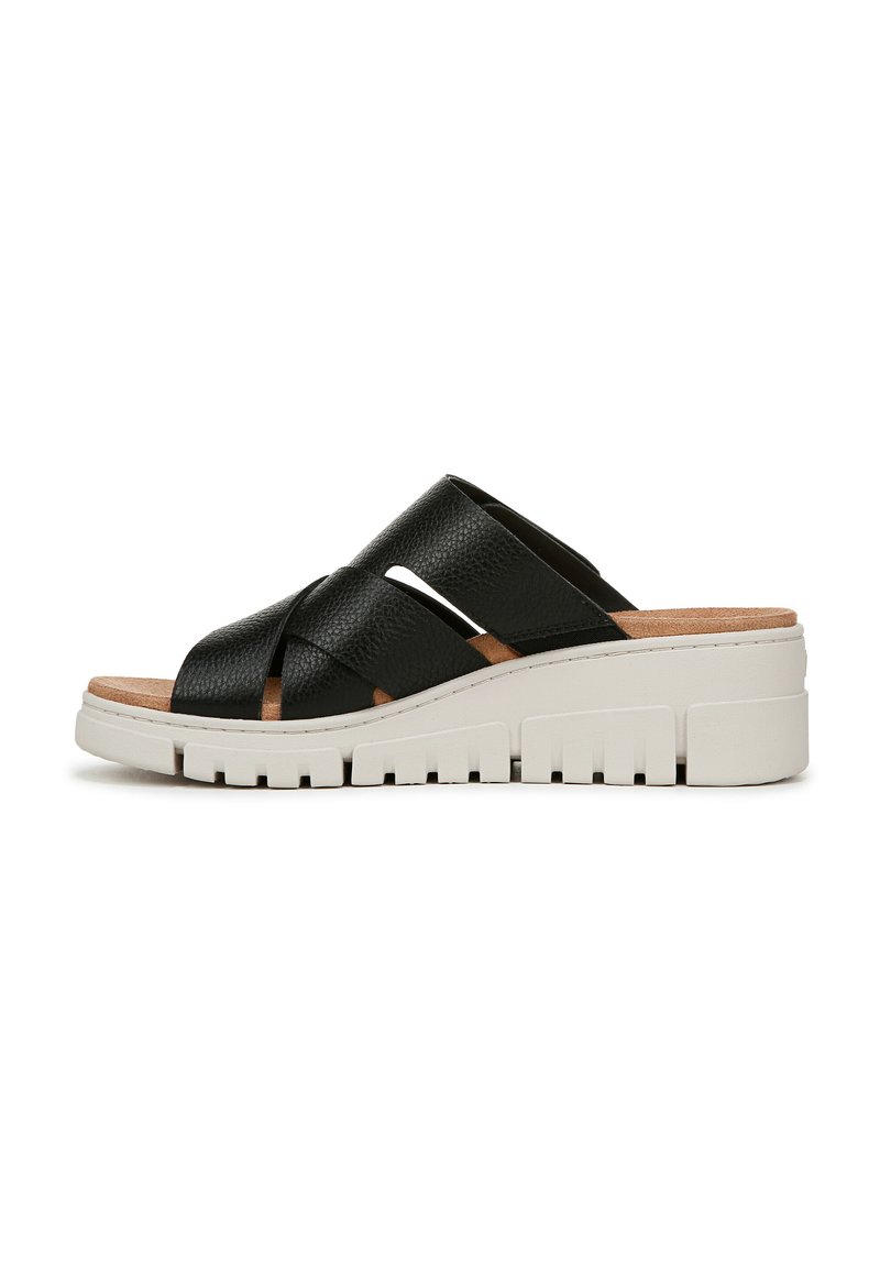 Sandali in pelle nera con cinturini incrociati, soletta in sughero sagomata e una robusta suola platform bianca con dettagli testurizzati.