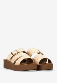 Chanclas beige con textura de cocodrilo, dos correas anchas, detalles de hebilla dorada y suela de plataforma marrón. Forro interior suave.