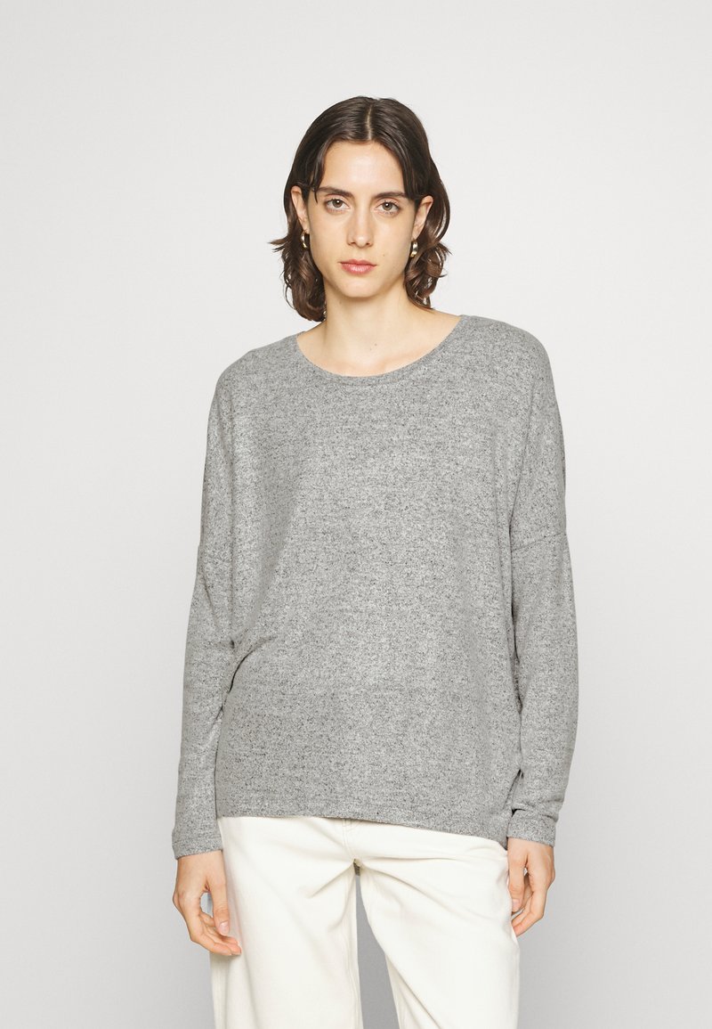 Light gray sweater with a round neck and long sleeves, made from a soft, textured material. Features a relaxed, slightly oversized fit.