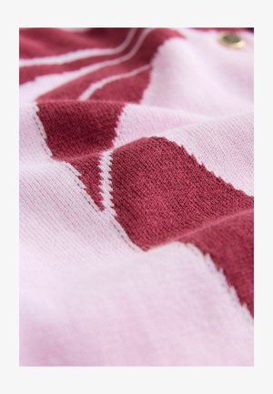 Pruhovaná pletenina v ružovej a burgundskej farbe s mäkkou textúrou a diagonálnym vzorom, doplnená kontrastným bielym prešívaním.