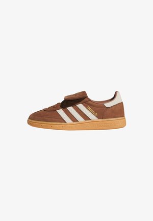 Zapatillas Adidas Spezial de ante marrón con rayas blancas, suela de goma, cordones y detalle de marca en el lateral y en la suela.