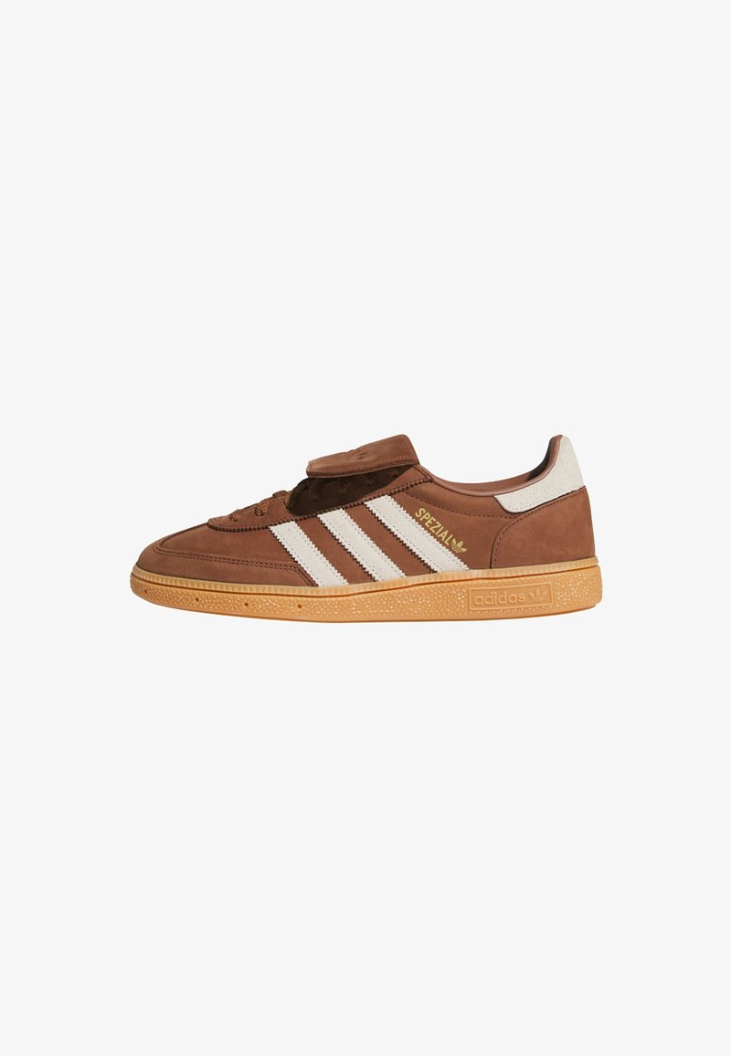 Hnedé semišové tenisky Adidas Spezial s bielymi pruhmi, gumovou podrážkou, šnurovaním a značkovým detailom na boku a podrážke.
