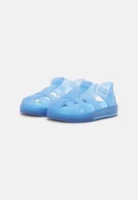 Blue translucent strap sandals featuring an open design, textured soles, and an adjustable buckle for a secure fit.