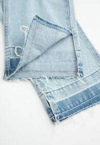 Jasnoniebieskie dżinsy z postrzępionym dołem, z lekko wyblakłą teksturą i prostym krojem nogawek. Wnętrze pokazuje rogi kieszeni.