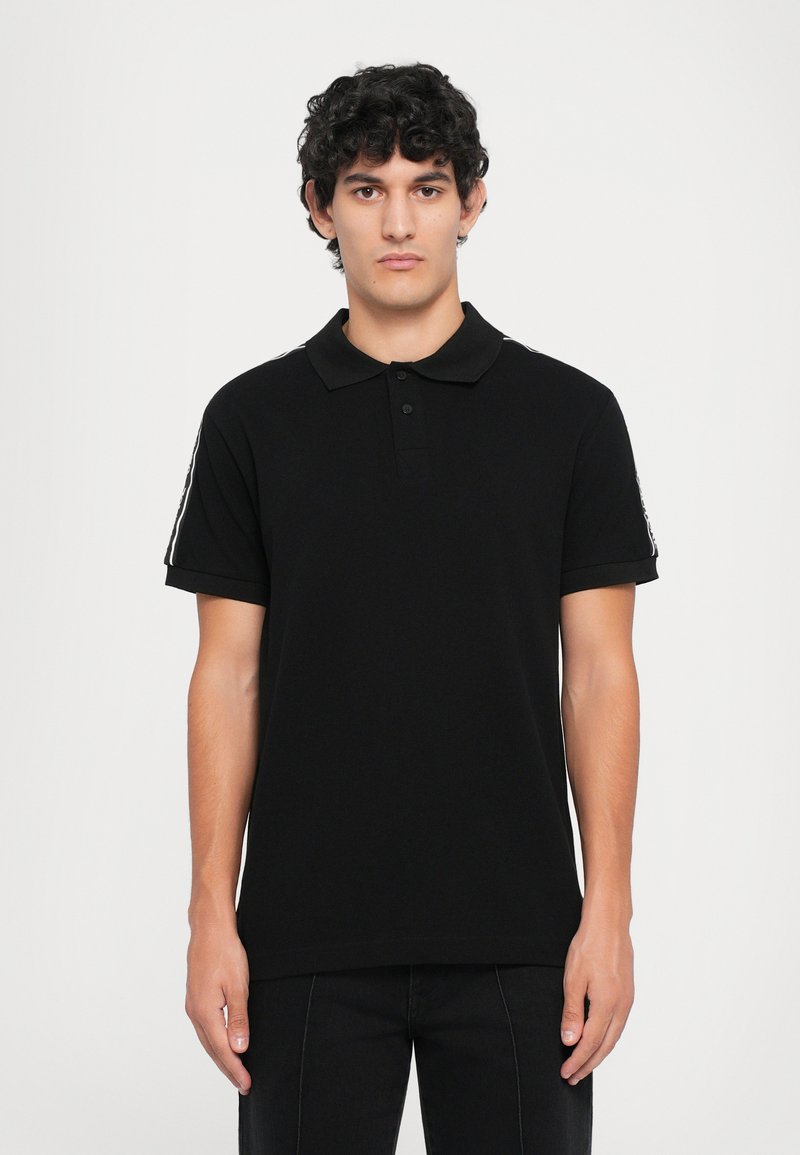 Black polo shirt with a collared neckline, short sleeves, and two-button placket. Features white accent stripes on the shoulders.