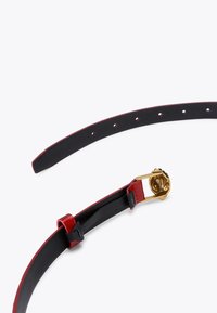 Zwarte en rode leren riem met een gouden gesp, voorzien van gaten voor aanpassing. De binnenkant is glad zwart, met een glanzend rode buitenlaag.