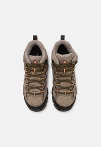 Beżowe buty trekkingowe z siateczkowym i zamszowym wierzchem, czarną gumową podeszwą, pomarańczowymi sznurówkami, wyściółką wokół kostki i wzmocnionym noskiem.