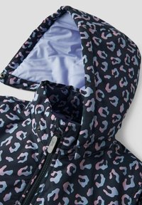 Hættetrøje i sort stof med et pink og blåt leopardmønster. Glat foret, frontlynlås og trykknapper til sikring af hætten.
