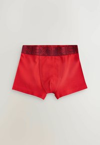 Boxer-briefs en coton rouge avec une ceinture élastique rouge foncé arborant le lettrage en relief "NEXT". Texture lisse et coupe ajustée.