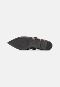 Zapato de tacón alto con punta afilada, que presenta un diseño de estampado de leopardo en tonos marrón claro y negro, y una suela negra texturizada.