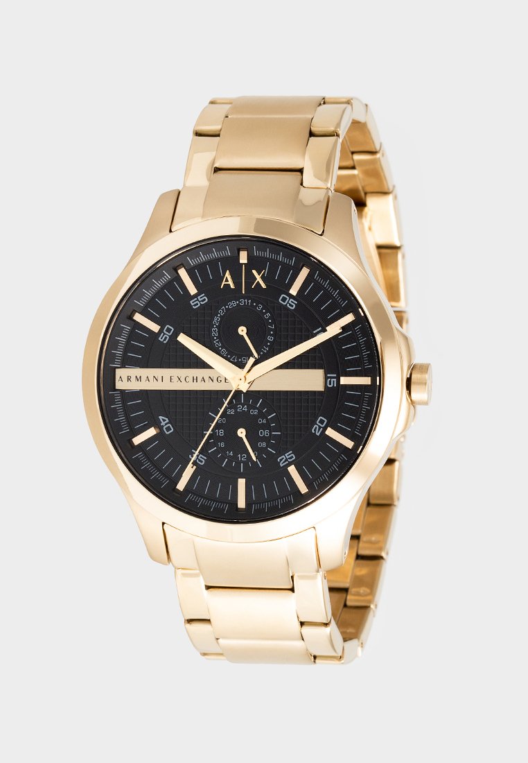 Reloj de pulsera de metal dorado con esfera negra, marcadores de hora dorados, dos subesferas más pequeñas y la marca "Armani Exchange" en la carátula.