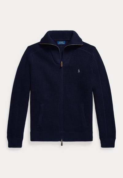 Navy zip-up sweater made of textured knit fabric. Features a high collar, two side pockets, and a small embroidered logo on the chest.