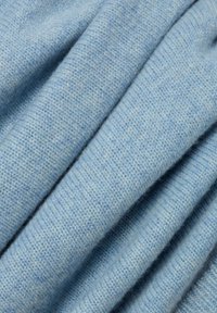 Jasnoniebieska dzianina o miękkiej, teksturowanej powierzchni. Charakteryzuje się prążkowanym wzorem oraz subtelnym melanżem w całym materiale.