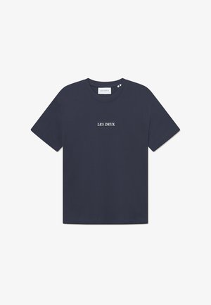 Camiseta de algodón azul marino con mangas cortas y cuello redondo. Presenta texto bordado en blanco "LES DEUX" en el pecho. Diseño simple.