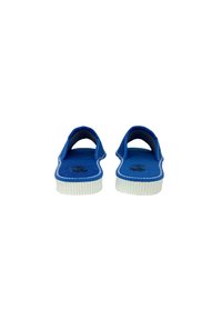 Pantofole di stoffa blu con una texture morbida, suola in gomma bianca, design aperto sul retro e cuciture a contrasto lungo i bordi.