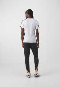 Nike Performance NIKE STRIKE PANT - Teplákové kalhoty - black/jersey gold/metallic gold