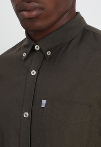 Donker olijfgroene button-up blouse van gestructureerd katoen, met een zak met een gestreept accent en zilverkleurige knopen.
