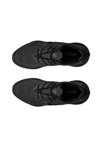 Black athletic shoes with a textured upper, featuring a mesh design and smooth accents, round toe, and black laces. Minimal branding visible.