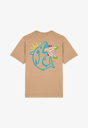 Tricou din bumbac bej, cu un grafic brodat al unui rechin albastru, având detalii colorate, inclusiv un soare și diverse produse alimentare, pe spate.