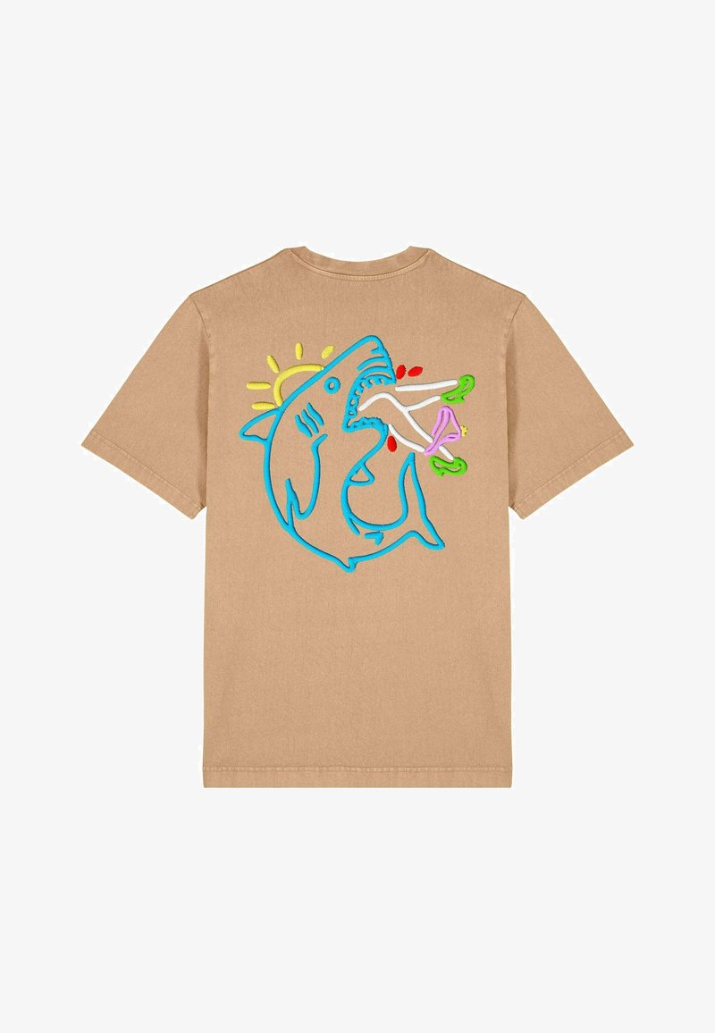 Camiseta de algodón color beige con un gráfico bordado de tiburón azul que presenta detalles coloridos, incluyendo un sol y varios alimentos, en la parte posterior.