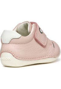 Scarpina per bambini in pelle rosa con tacco bianco e strap in Velcro. Presenta una cucitura decorativa e un elemento di design rotondo. Marchio GEOX sul tallone.