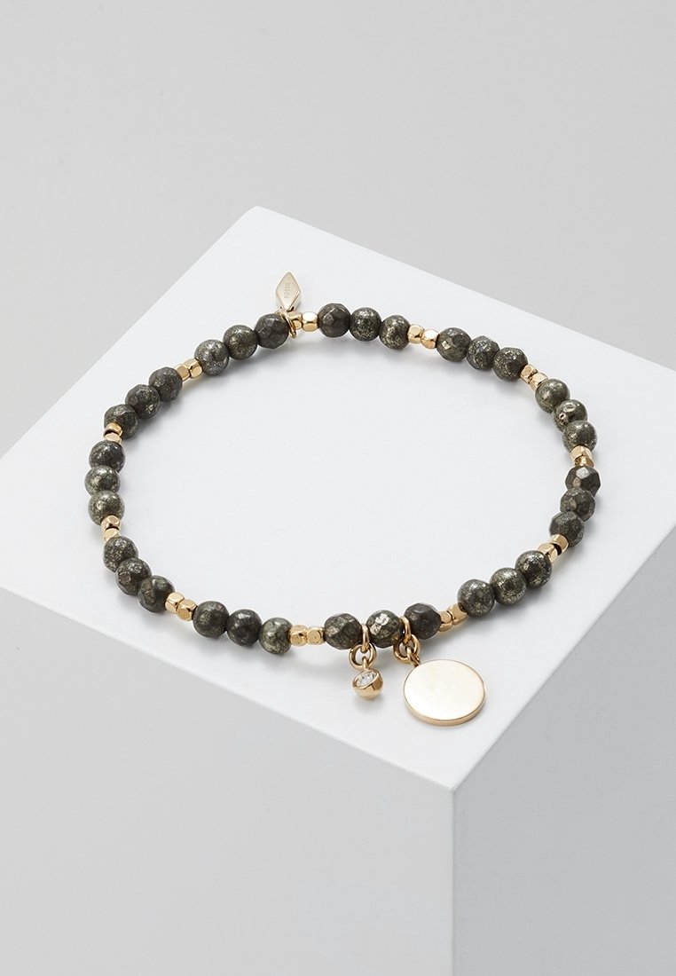 Bracelet extensible avec perles facettées foncées, petits espaces dorés, et deux breloques en or — une ronde et une avec une petite pierre claire.