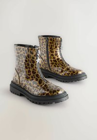 Leopardenmuster Knöchelstiefel aus glänzendem Material mit schwarzen Gummisohlen und Reißverschlüssen, mit sternförmigen Akzenten an den Ziehlaschen.