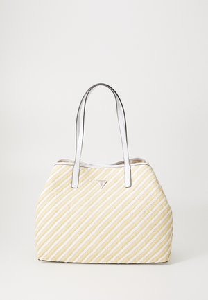 Striped tote bag in cream and yellow with white straps. Features a triangular logo and a textured woven pattern.