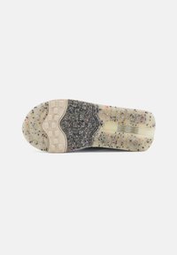 Suela de zapato con un diseño texturizado y moteado en tonos de gris, negro y blanco. Presenta un agarre con patrones y áreas de transición suaves.
