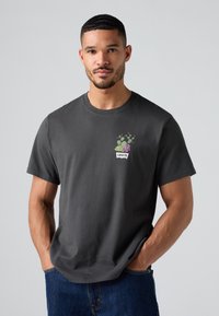 Tricou din bumbac gri închis, cu mâneci scurte, care prezintă un grafic colorat cu cactuși și un design cu eticheta "Levi's" pe partea din față.