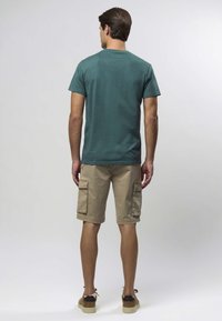 Teal kortermet skjorte, khakifargede cargoshorts med to sidelommer, og brune joggesko. Enkelt design og ledig passform.