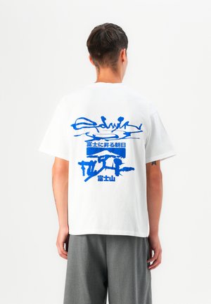T-shirt en coton blanc avec un grand design graphique bleu au dos, représentant des formes de montagnes et de paysages abstraits avec du texte.