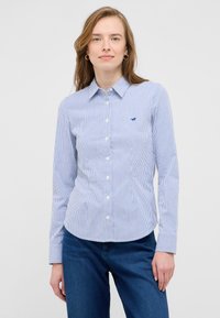Blue and white striped button-up shirt with a collar, long sleeves, and a small embroidered logo on the chest. Smooth cotton fabric.
