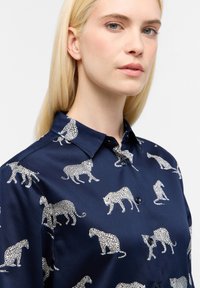 Marineblaues Hemd mit Leopardenmuster in Weiß, aus glattem Stoff mit klassischem Kragen und subtiler glänzender Oberfläche.