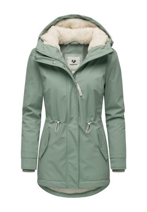 Veste imperméable vert clair avec une douce doublure en fausse fourrure, taille ajustable par cordon et deux poches avant. Elle possède une capuche et une fermeture éclair.