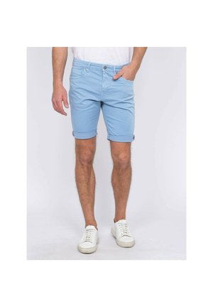 Shorts en coton bleu clair avec un ourlet roulé, dotés de poches avant et d'une fermeture à bouton. Portés avec des baskets blanches.